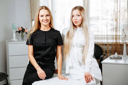 Two successful confident beauty salon female owners looking at camera. Cheerful female beautician is working with cosmetology.の写真素材