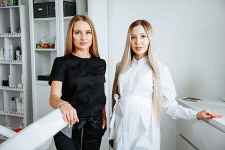 Two successful confident beauty salon female owners looking at camera. Cheerful female beautician is working with cosmetology.の写真素材
