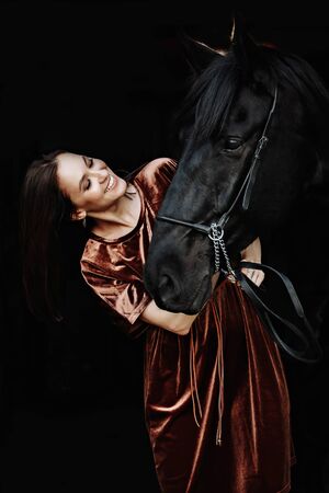 Wonderful lady with black horse in the stablesの写真素材