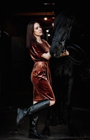 Wonderful lady with black horse in the stablesの写真素材