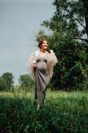 Young happy pregnant woman relaxing and enjoying life in nature. Outdoor shotの写真素材