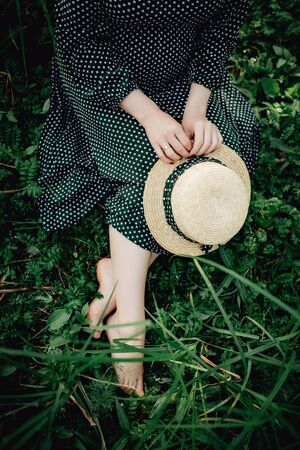 Close up of pregnant belly in nature. Summer dress and hatの写真素材