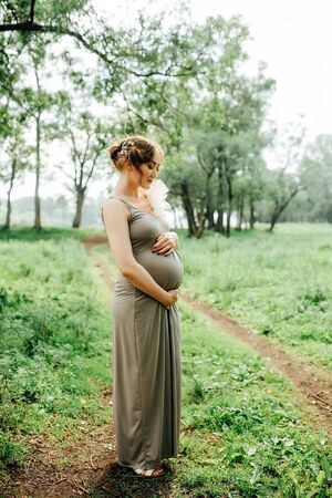 Young happy pregnant woman relaxing and enjoying life in nature. Outdoor shotの写真素材