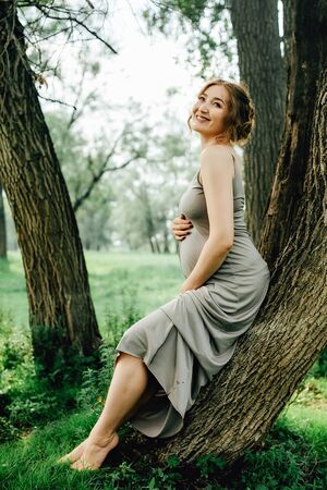 Young happy pregnant woman relaxing and enjoying life in nature. Outdoor shotの写真素材