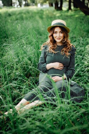 Young pregnant woman relaxing in park outdoors, healthy pregnancy.の写真素材