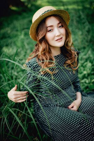 Young pregnant woman relaxing in park outdoors, healthy pregnancy.の写真素材