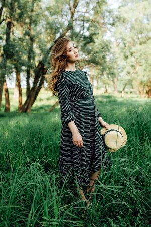 Pregnant woman posing in a green park. young happy pregnant woman relaxing and enjoying life in natureの写真素材