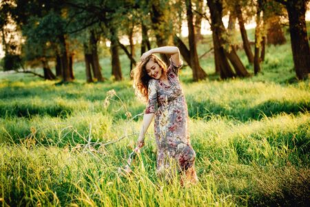 Portrait of beautiful pregnant woman in a green fieldの写真素材