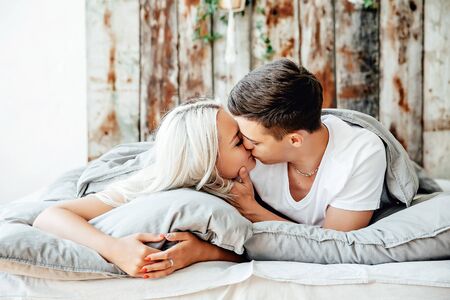 Close up portrait of romantic young man and woman in bed at home. Relationships, love, closeness.の写真素材
