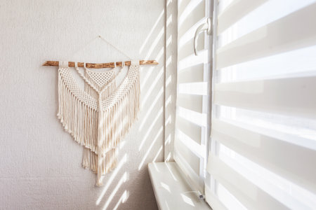 Handmade macrame wallhanging. 100% cotton wall decoration with wooden stick hanging on a white wall....