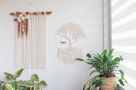 Macrame Wall hanging on white wall. ECO friendly modern knitting DIY natural decoration concept in the interior. Handmade 100% cotton. Female hobby.の写真素材