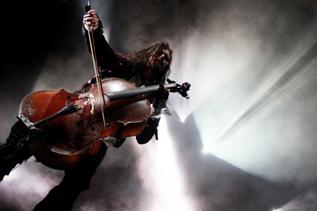 Concert photo of man playing cello with background lights