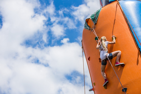 girl doing rock climbing on artificial climbing wallの写真素材