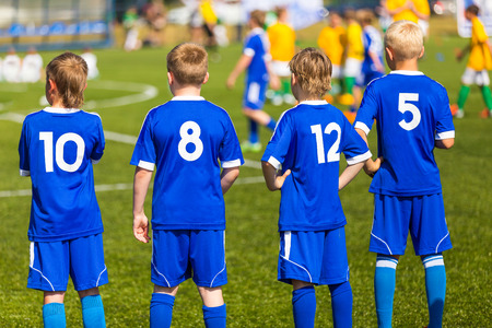 Football soccer match for children. Kids waiting on a bench.の写真素材