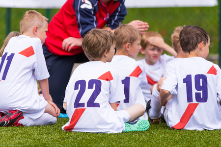 Coach giving children's soccer team instructions. Football; soccer; handball; volleyball; match for children. shout team, football soccer game. team workの写真素材