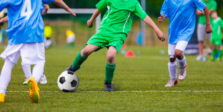 Youth soccer football teams kicking soccer ball on a sports pitch. Soccer tournament for young footballers.の写真素材
