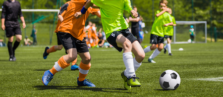 Young Boys Playing Soccer Football Match on Pitch. Kids Running and Kicking Soccer Ball on Green Grass. Soccer Children Gameの写真素材