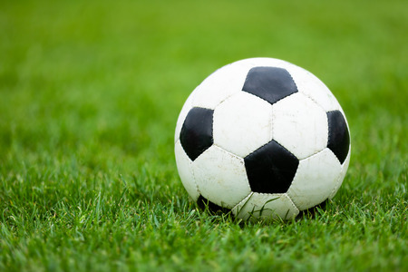 Classic Soccer Football Ball on Soccer Pitch. Green Grass Soccer Field. Soccer Turf in the Backgroundの写真素材