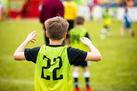 Kids Football Player on a Grass Soccer Field
