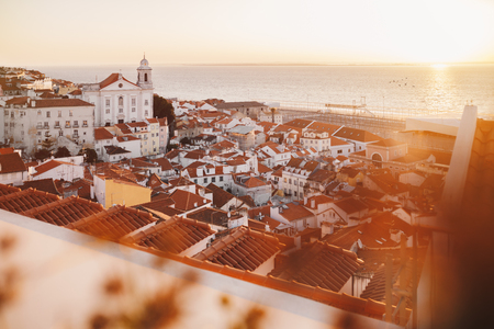 Sunrise Over Lisbon Old Town Alfama - Portugal. Lisbon Golden Hour Skyline. Sun Rising Over Tagus River. Balcony View on Old Town of Lisbonの写真素材