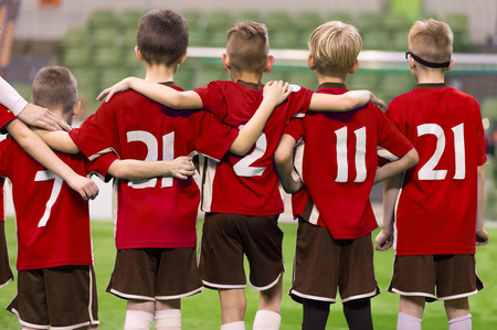 Children in Sportswear Standing in Team. Kids in Red Jersey Shirts. Kids Standing in Row During Penalty Kicksの写真素材