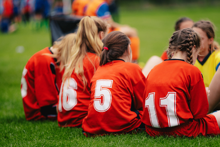 Girls in sports soccer team outdoors. Female physical education class on sports grass field. Young...