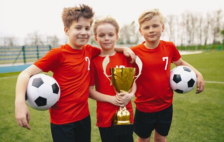 Happy Sports Soccer Team Players Holding Trophy. Winners of Youth Football Tournamentの写真素材