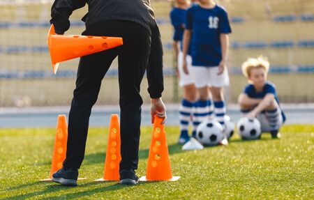 Soccer Coach Placing Training Cones for Kids Sports Team. Children on Soccer Football Class....