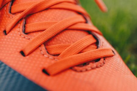 Close-up image of sports cleats. Red sports cleats u designed for field sports such as soccer, football, and baseballの写真素材