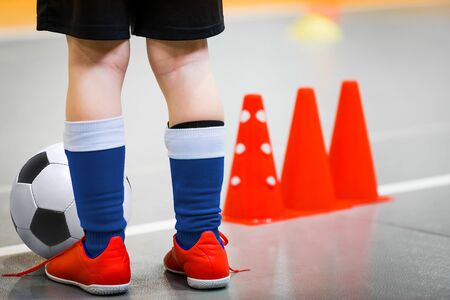 Children playing football in school gymnasium. Indoor soccer - futsal training for school kids....