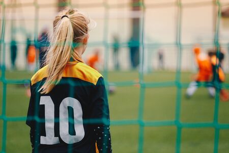 Soccer girl playing game as a goalie. Youth female football team playing tournament matchの写真素材
