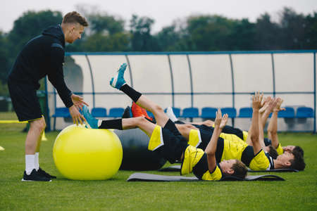 Youths on Stability Soccer Training on Balance Cushions. Sports Balance Training. Young Soccer Players Improving Core Strength, Balance and Stability Skills. Grass Football Field. Coaching Soccerの写真素材