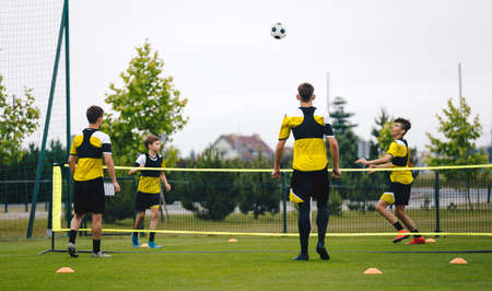 Youth teenage football players playing football tennis on training unit. Teenagers practicing soccer...