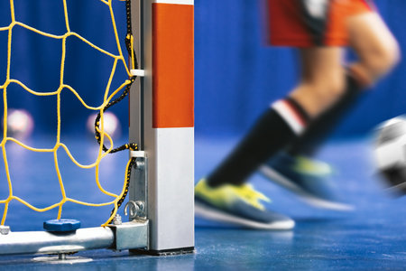 Indoor Soccer Goal - Close up on Square Goal Post. Futsal training for youth team. Young boy with soccer ball running. Indoor football soccer school practice. Kid in sportswearの写真素材