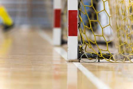 Indoor Football Goal With Yellow Net. Red and White Soccer Goal Post. Futsal White Sideline on Wooden Parquet Floorの写真素材