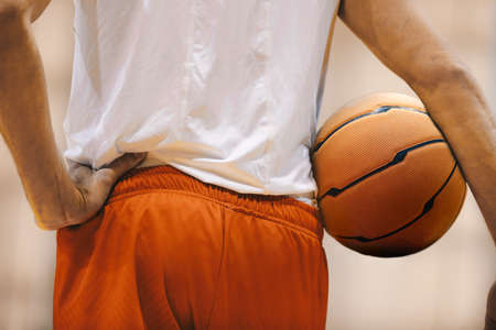 Basketball player holding game ball. Basketball training session. Closeup image of basketballの写真素材