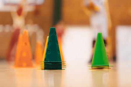 Basketball training cones on wooden floor. Colorful training equipment at basketball practice courtの写真素材