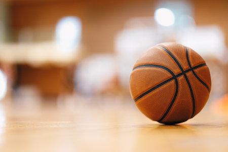 Close-up image of basketball ball over floor in the gym. Orange basketball ball on wooden parquet.の写真素材