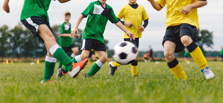 Group of Young Soccer Players Playing Football Game at Grass Venue. Happy School Boys Kicking Soccer Ball. Sports Outdoor Competition Between Two Teamsの写真素材