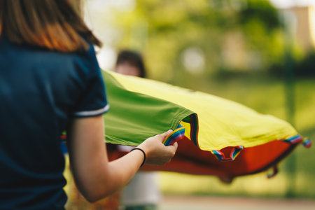 Little boy Holding Rainbow Blanket Toy and Having Fun With Other Kids. Kid at Kindergarten Playing Outdoor Togetherの写真素材
