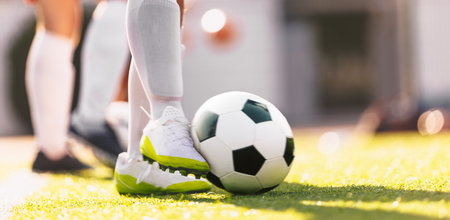 Soccer Ball in Motion Kicked by a Soccer Player. European Football Horizontal Background. Player in white soccer cleats and soccer socks. Moment of football ball kickの写真素材
