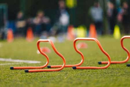 Sports Training Hurdles. Kids in Soccer Practice in Blurred Background. Football Practice Equipment