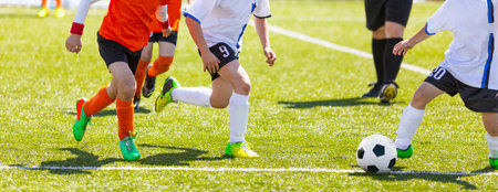 Kids Kicking Soccer School Tournament Match. Children Playing Sports Game. Running European Footballers. Young Athletes Compete in Football Gameの写真素材