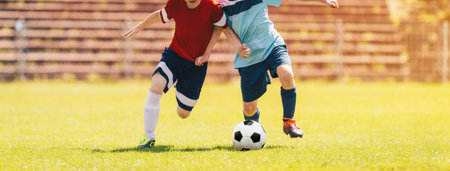 Kids Soccer Game. Children Boys Compete in Duel on Football Tournament Match. Ball Kick Moment. Young Boy Kicking Ball. School Kids Running Classic Soccer Ball on Grass Pitchの写真素材