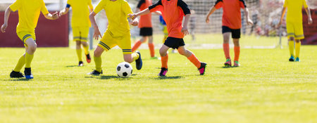 Youth Soccer League. Football Soccer Players Running and Kicking a Soccer Ball. School Boys Compete in Soccer League. Young Football Players on a Match. Youth European Football Players in Actionの写真素材