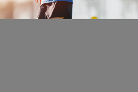 Little girl attending football training on school field. School girl on physical education class. Soccer practice for youth. Football player with soccer ball in slalom drillの写真素材