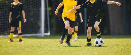 Kids play European football. Football soccer match for children. Boys playing football game on school tournament. Dynamic, action picture of kids competition during playing football. Sports backgroundの写真素材