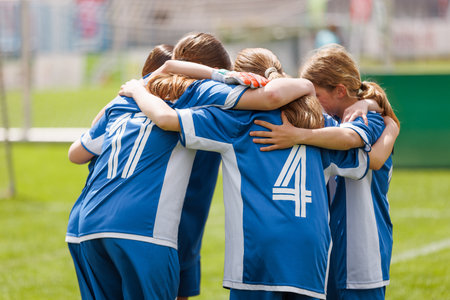 Youth Girls' Soccer Team in a Pre-Game Huddle, Showing Team Unity and Sportsmanship on the Fieldの写真素材