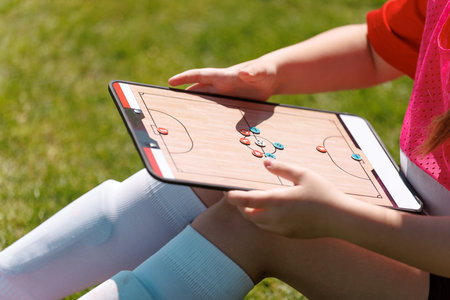 Young Soccer Player Analyzing Game Strategy on Tactics Board During Outdoor Practice Session on Grass Fieldの写真素材