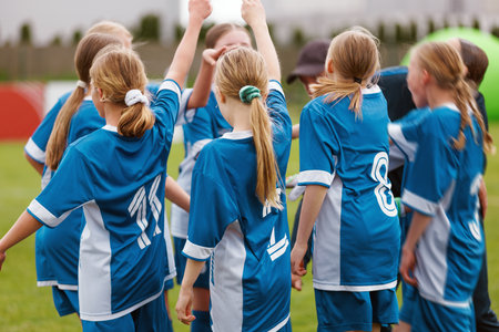 Youth Girls' Soccer Team Celebrating Together on the Field. Team Spirit, Unity, and Sportsmanship in Blue Jerseys During a Match or Training Sessionの写真素材